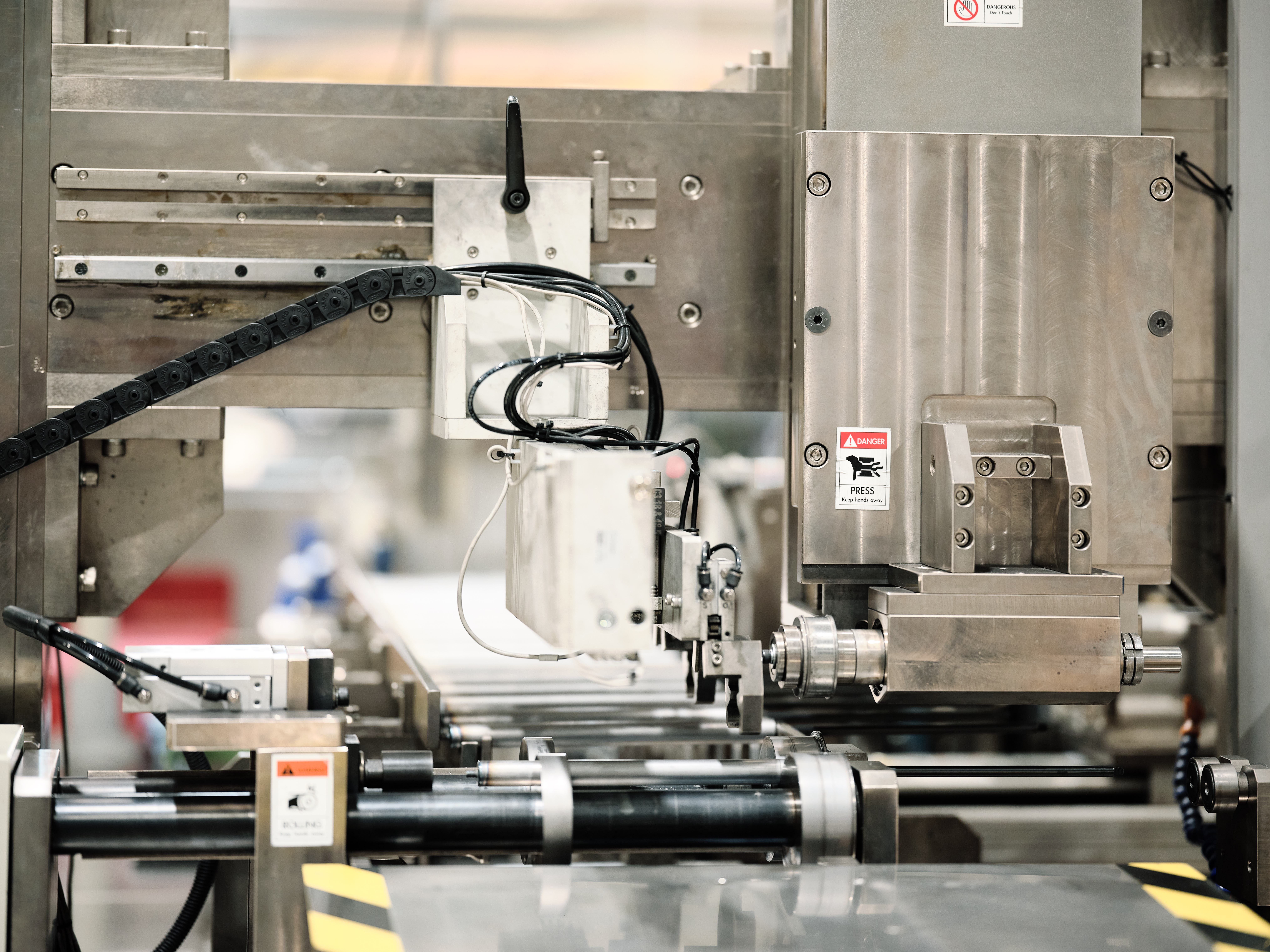 Industrial machinery operating in a springfactory, with robotic arms and conveyor belts moving materials. 
