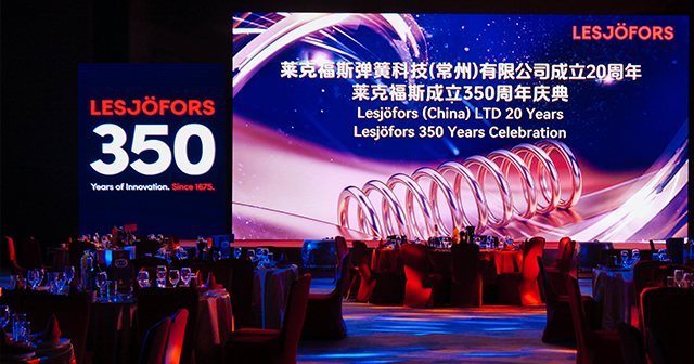 Event venue with a large screen for the Lesjöfors 350-year anniversary celebration. Text on screen reads: “Lesjöfors (China) LTD 20 Years, Lesjöfors 350 Years Celebration.”