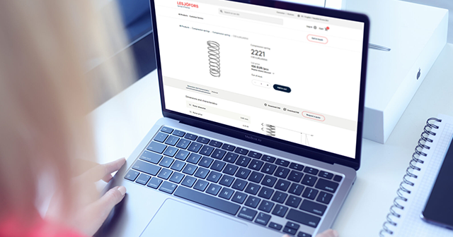 A person using a laptop to view a compression spring on the Lesjöfors webshop.