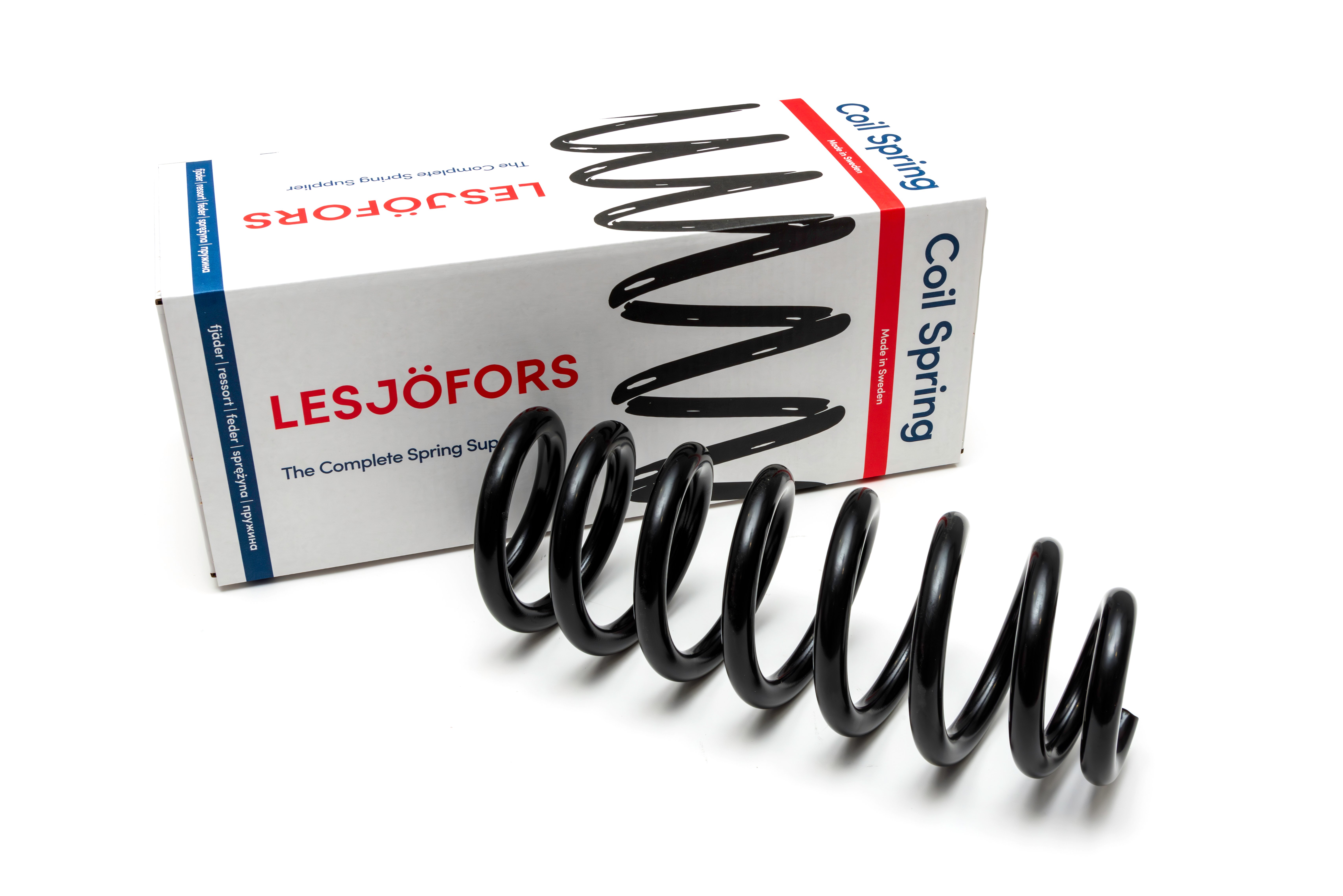 A black chassis spring is displayed in front of a branded Lesjöfors box, suggesting automotive or mechanical use.