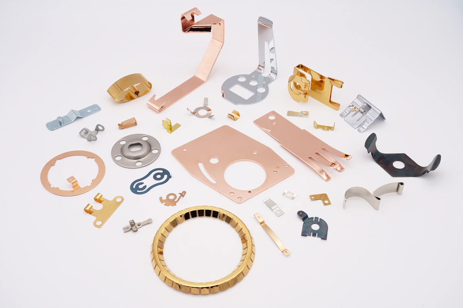 A large assortment of custom metal stamped parts in multiple materials and colors.