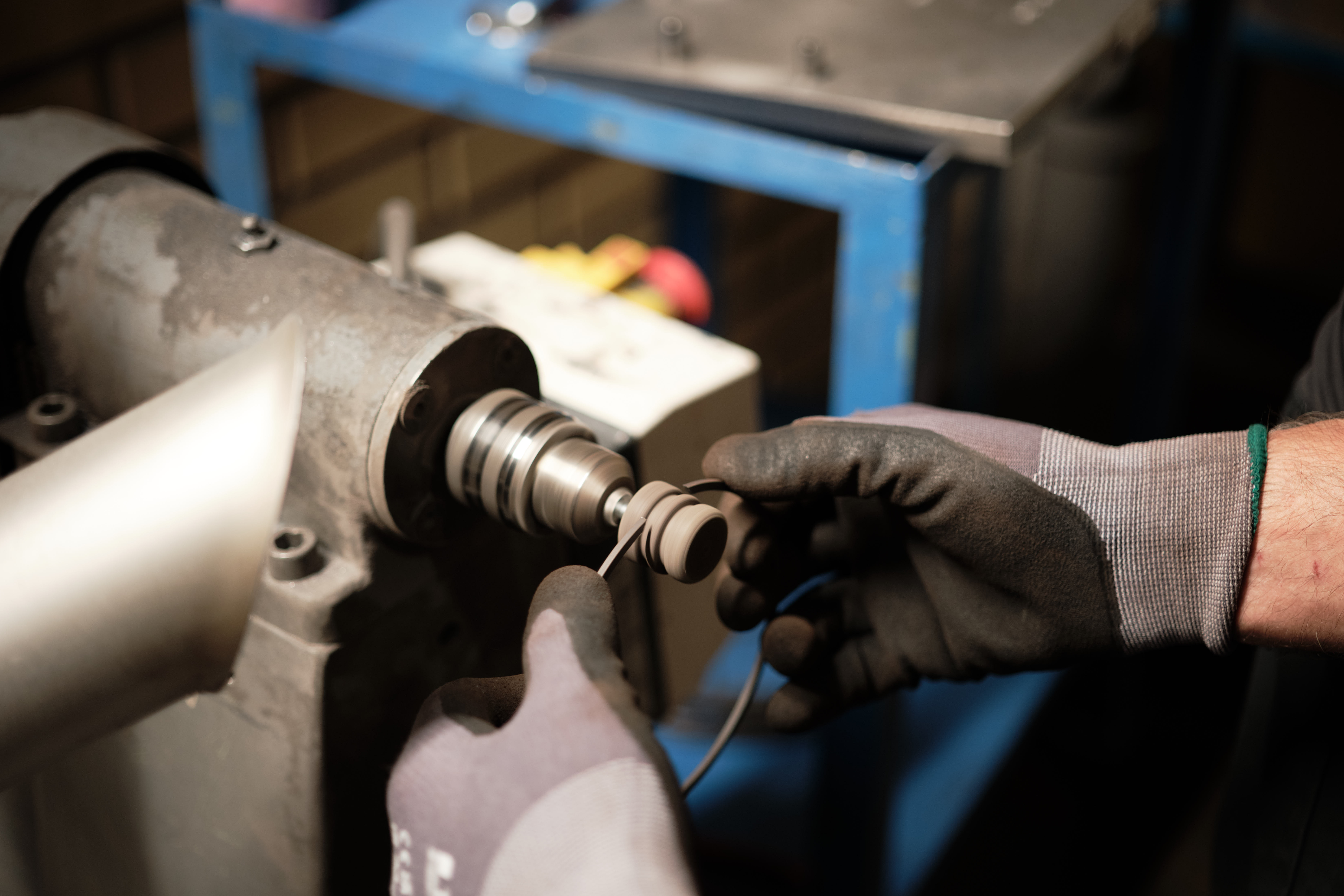 A Lesjöfors factory worker forming a metal wave washer with the help of a machine.