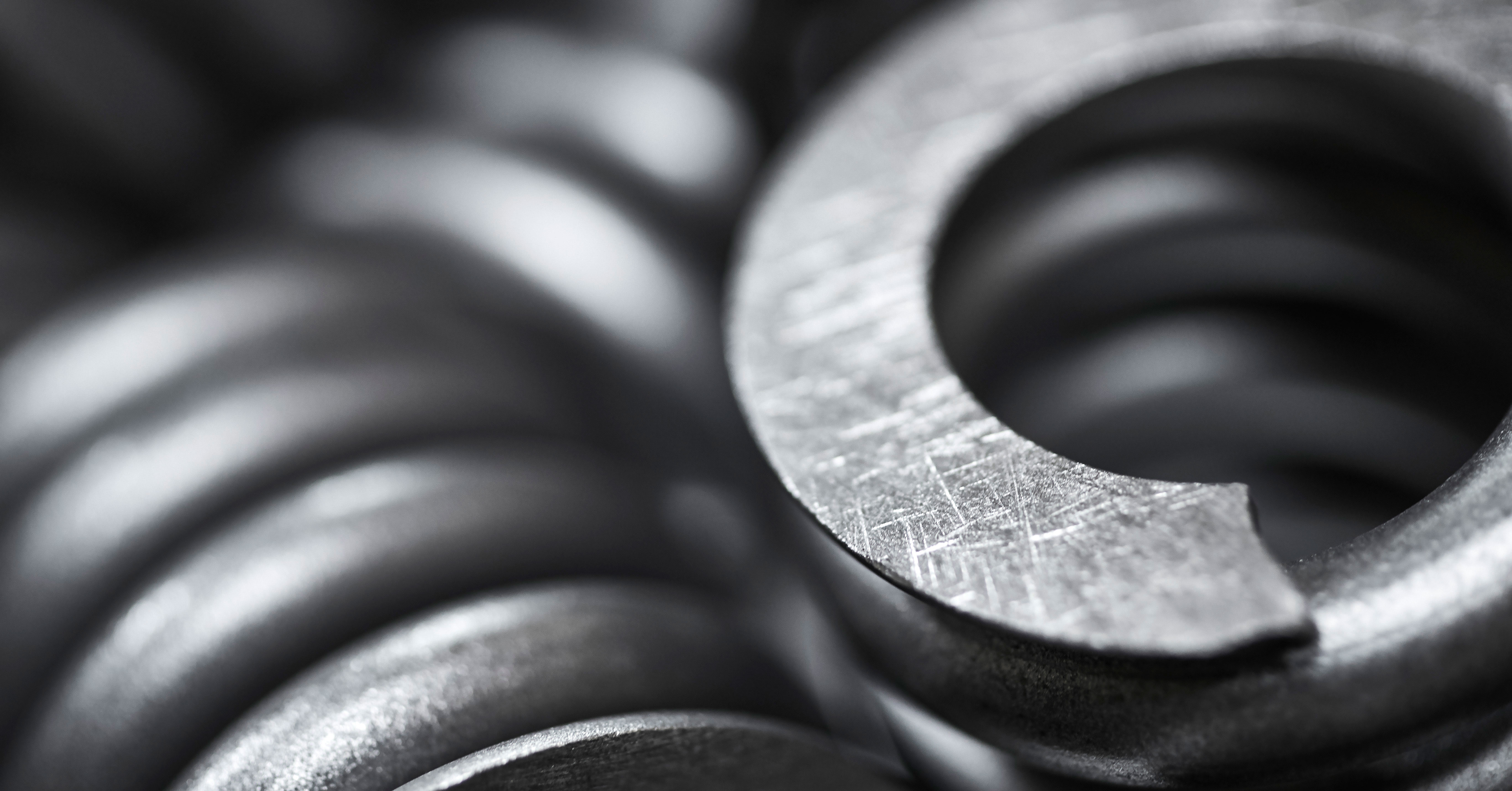 Close-up of a pile of dark gray metal compression springs.